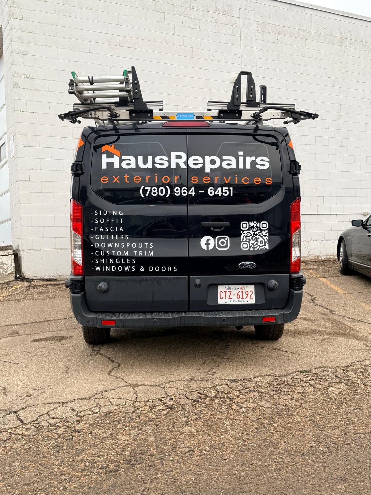 HausRepairs black van wrap with services list, rear view