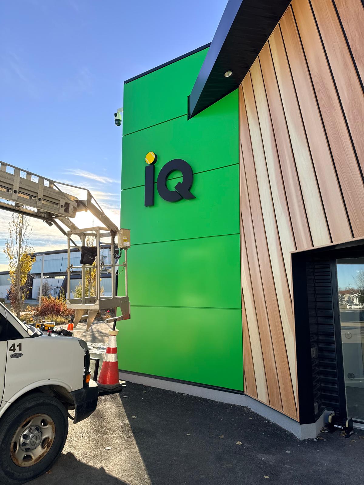 iQ dimensional letter sign installed on a green facade