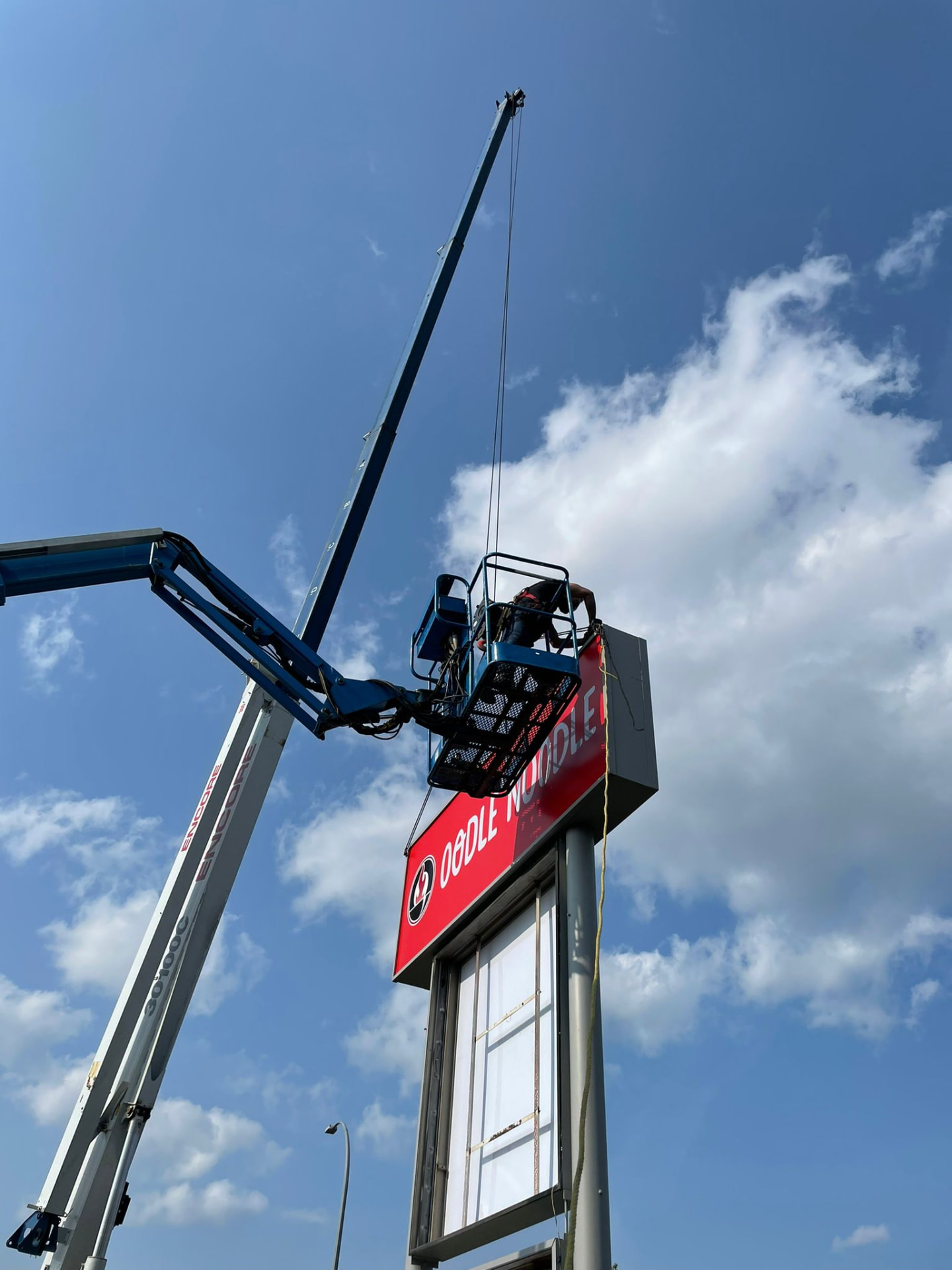 Oodle Noodle pylon sign installation with a crane