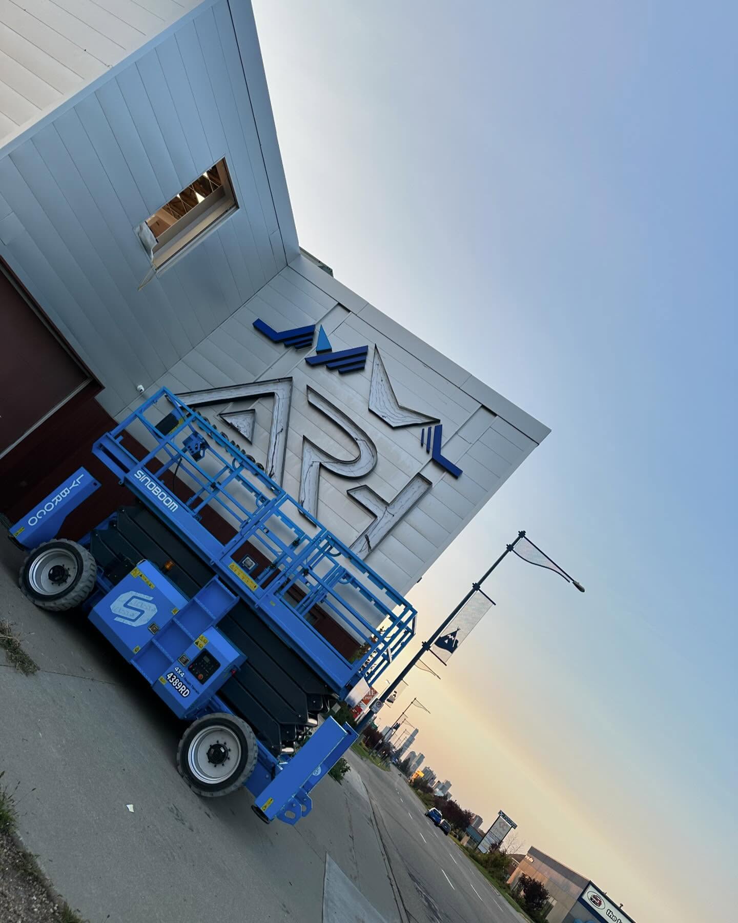 Channel letter sign install with a lift on a building facade